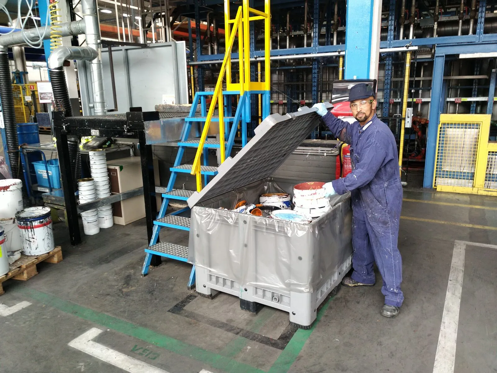 Opérateur collectant des déchets de peinture dans un conteneur dédié chez AkzoNobel à Wapenveld
