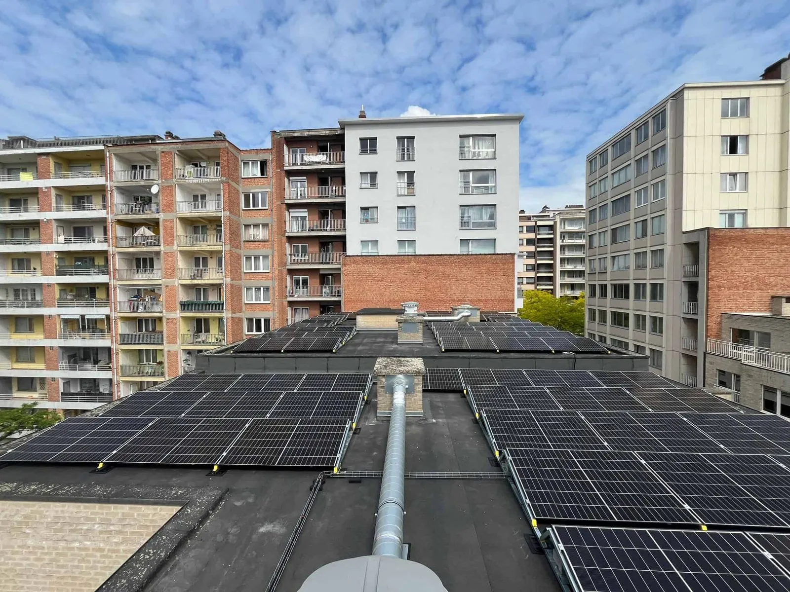 Zonnepanelen op het platte dak van een appartementsgebouw van Axial Invest in Koekelberg