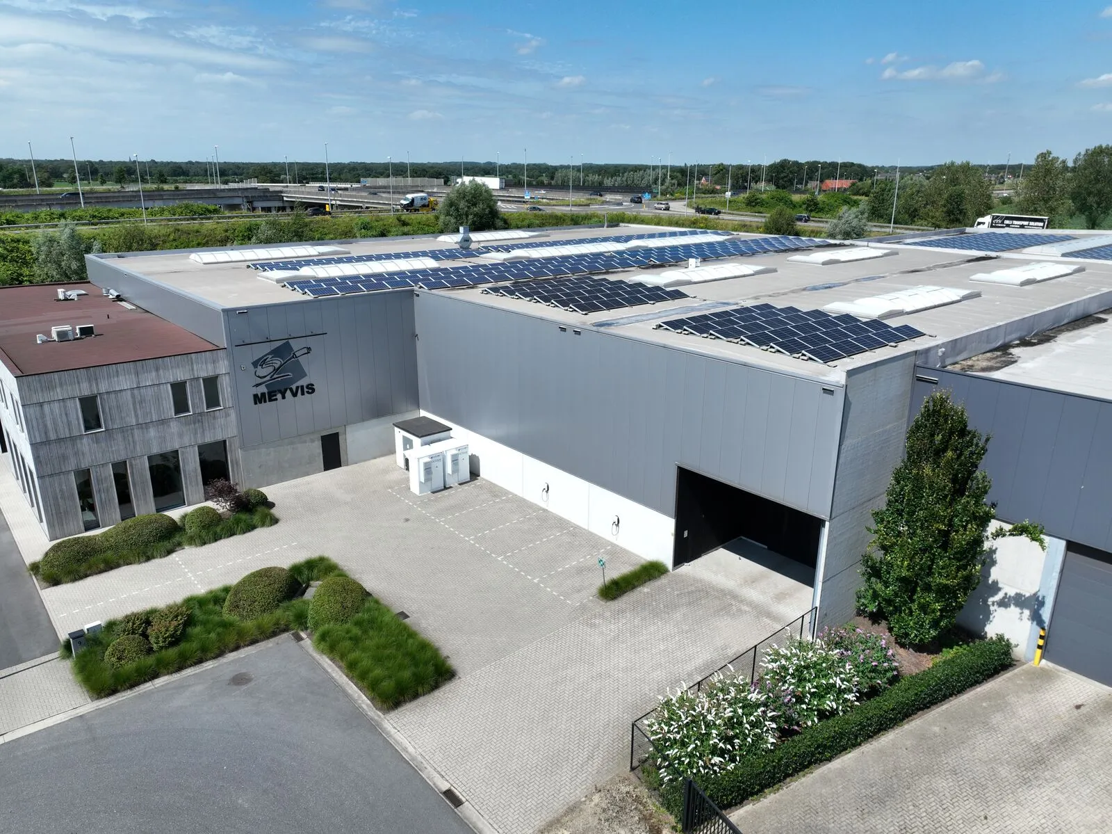 Site d'entreprise avec panneaux solaires en toiture et batterie derrière le compteur pilotée par Yuso