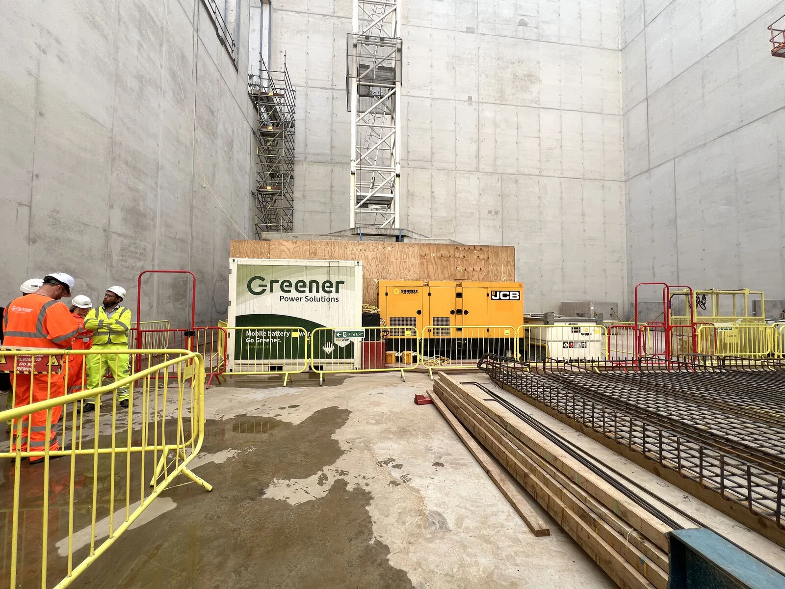 Une batterie Greener à côté d'un groupe électrogène, en configuration hybride, sur un chantier de Careys