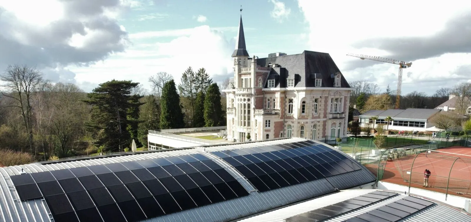 Panneaux solaires sur la toiture cintrée du club David Lloyd à Uccle