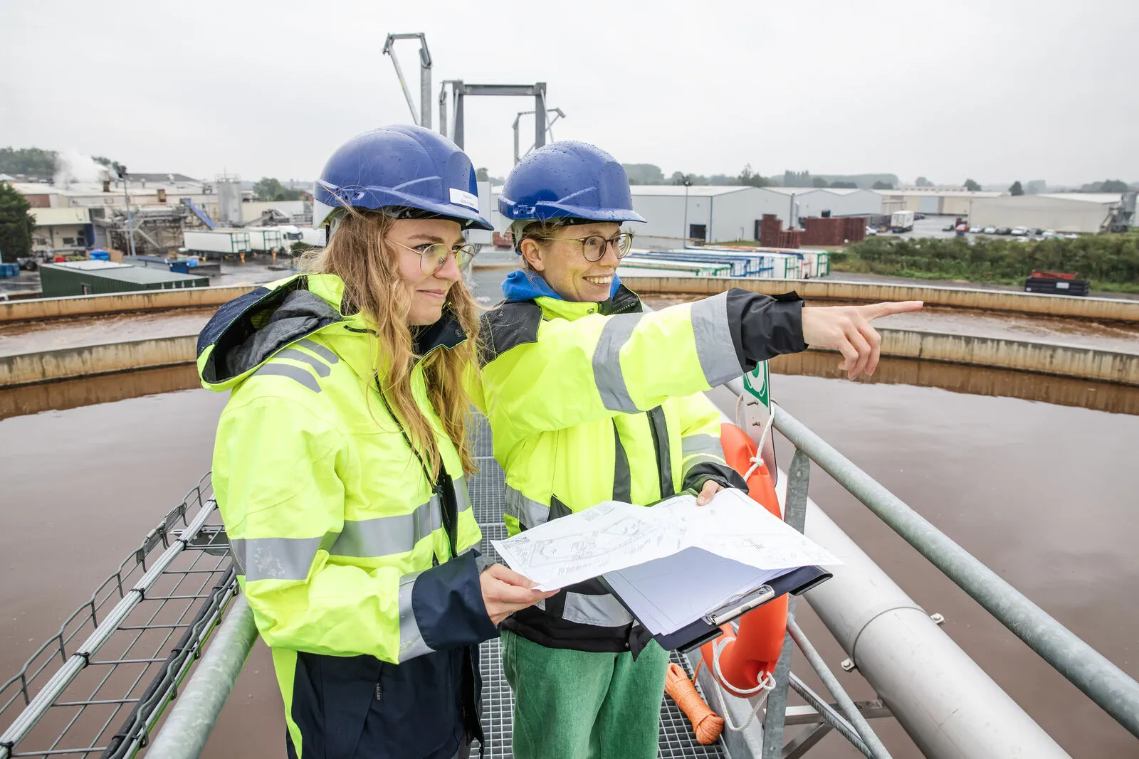 Ingenieurs van Trevi bekijken plannen boven een zuiveringsbekken
