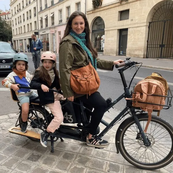 Un parent et deux enfants sur un longtail WELGO en ville