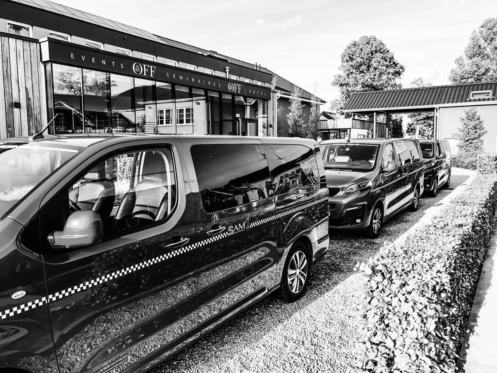 Des vans SAM-Drive alignés devant un bâtiment