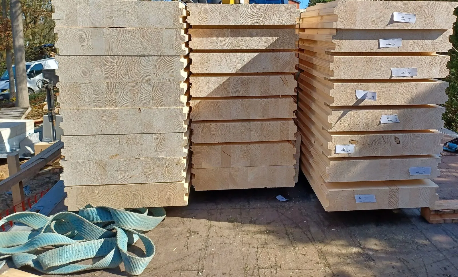 Houten vloerelementen gestapeld op de werf voor de plaatsing