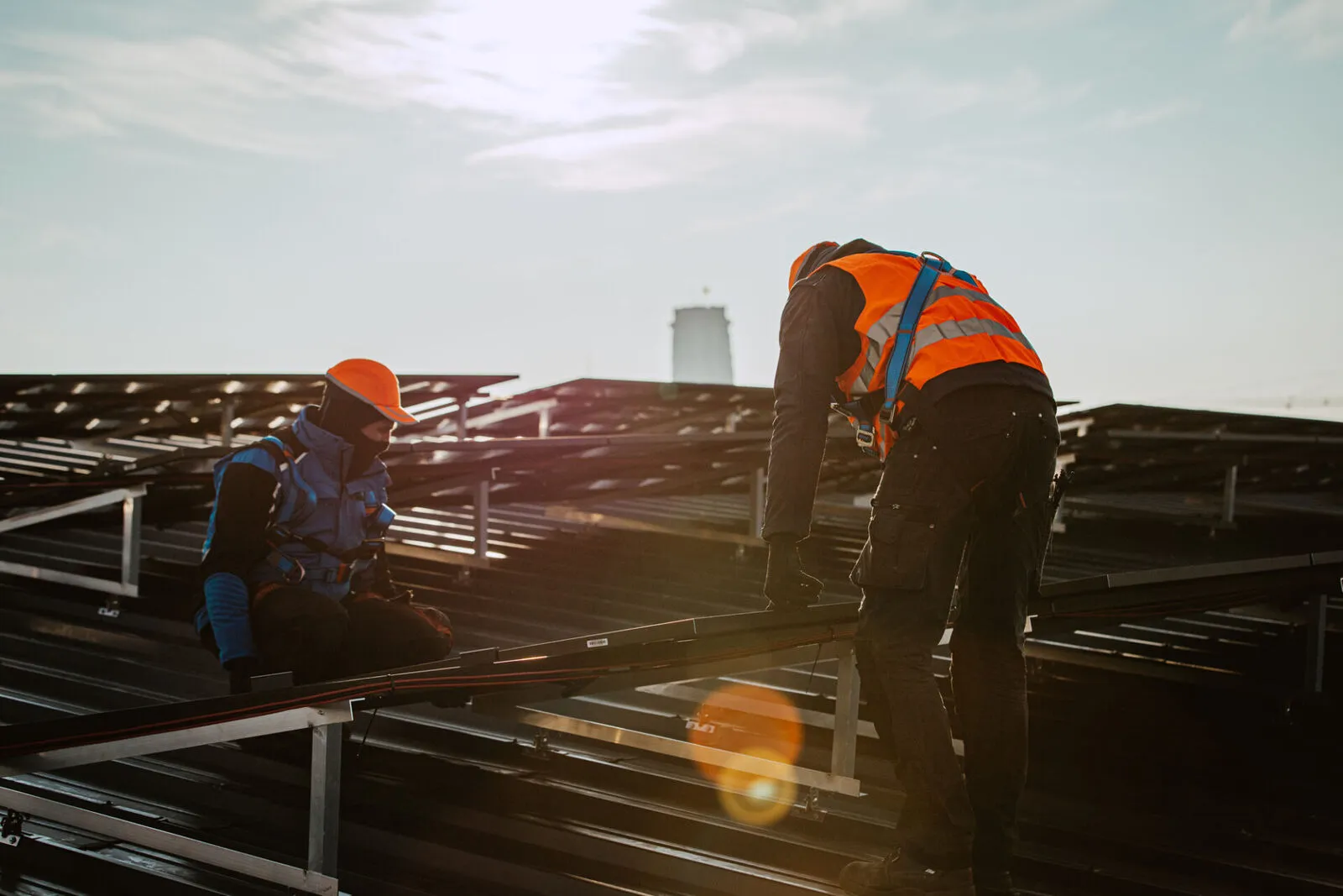 Installateurs Futech posant des panneaux solaires sur une toiture plate industrielle