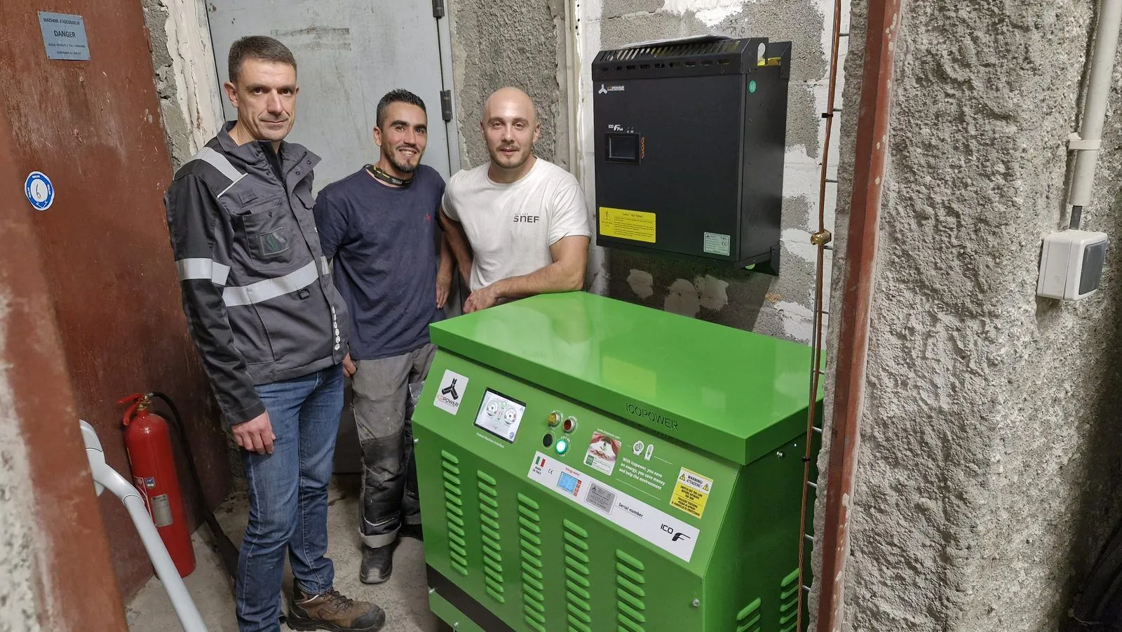Het installatieteam naast een Icopower-unit in een kelder