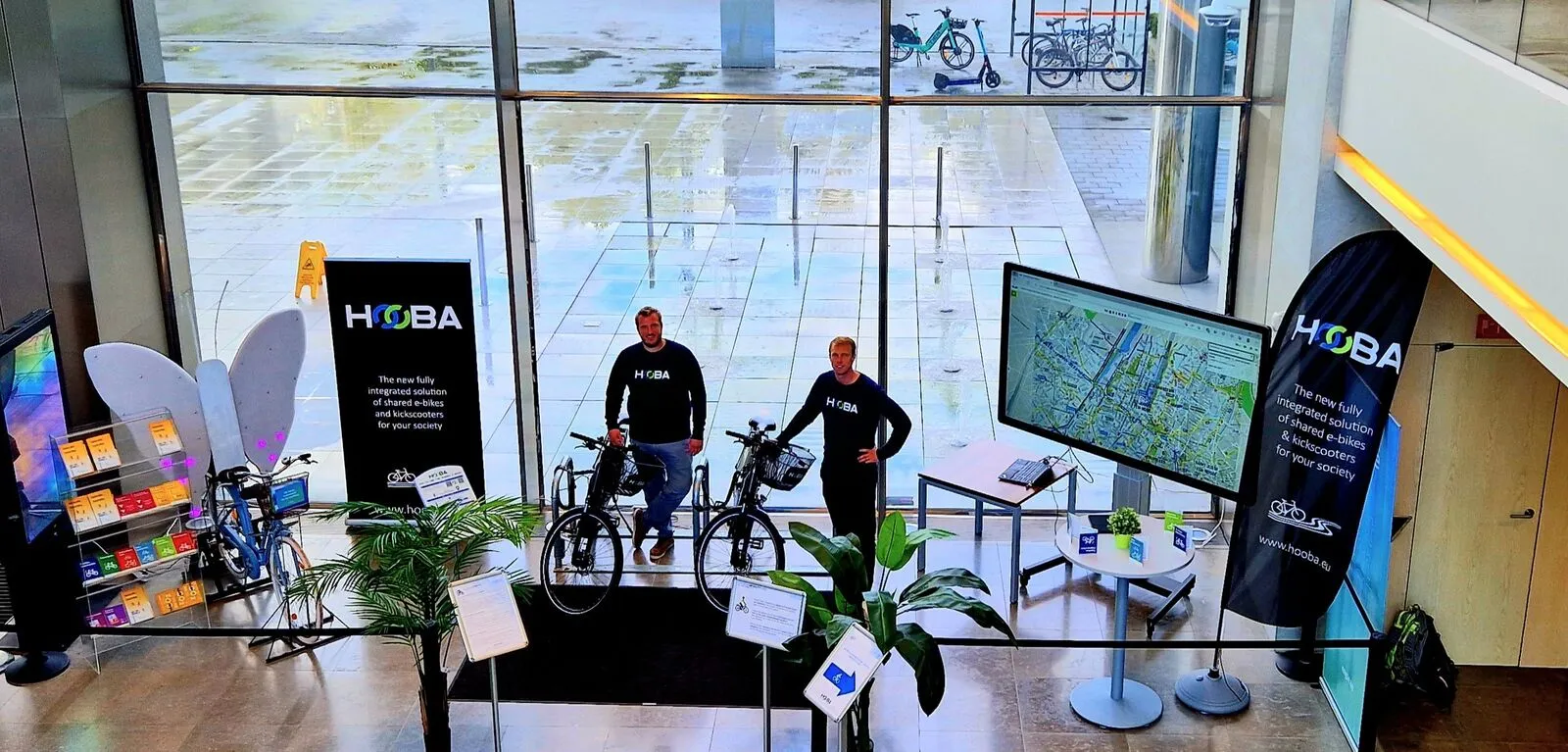 Een infostand van HOOBA en e-bikes in de lobby van een kantoorgebouw