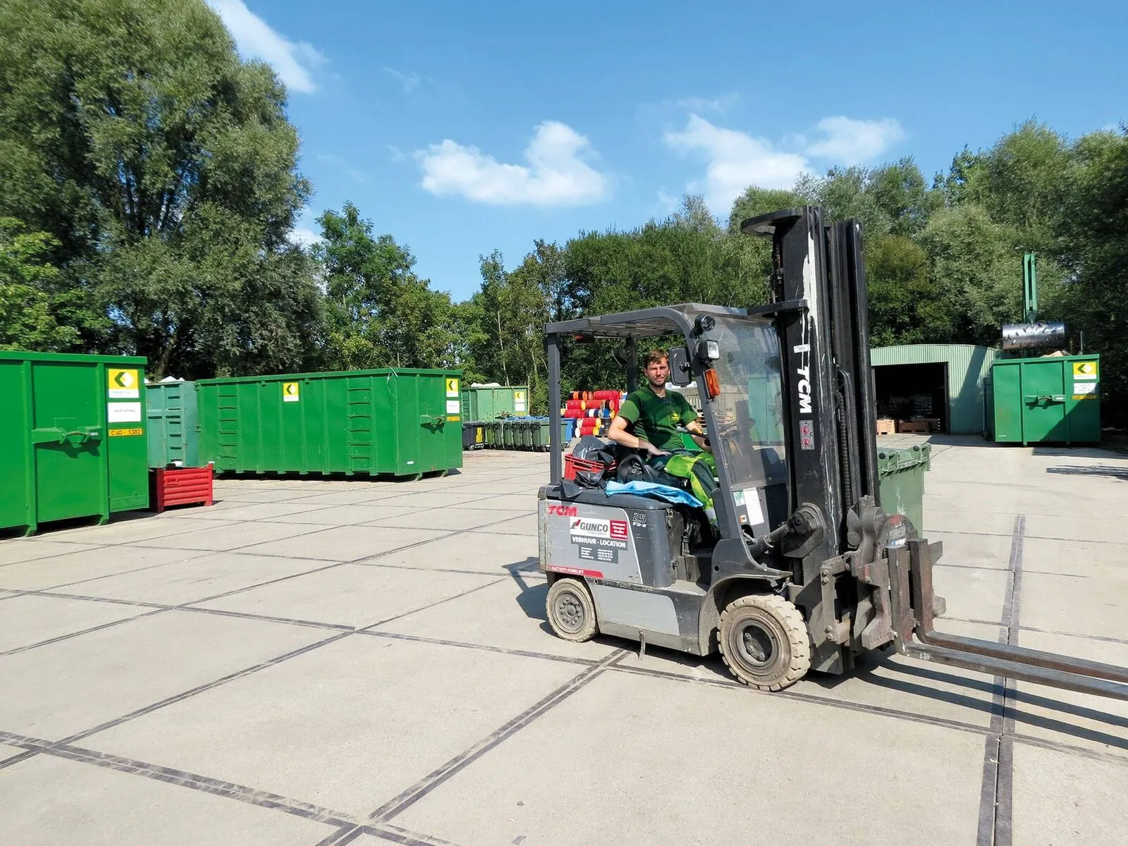 Un collaborateur Vanheede sur site déplace des conteneurs dans la zone de recyclage d'un client, dans le cadre de Total Waste Care