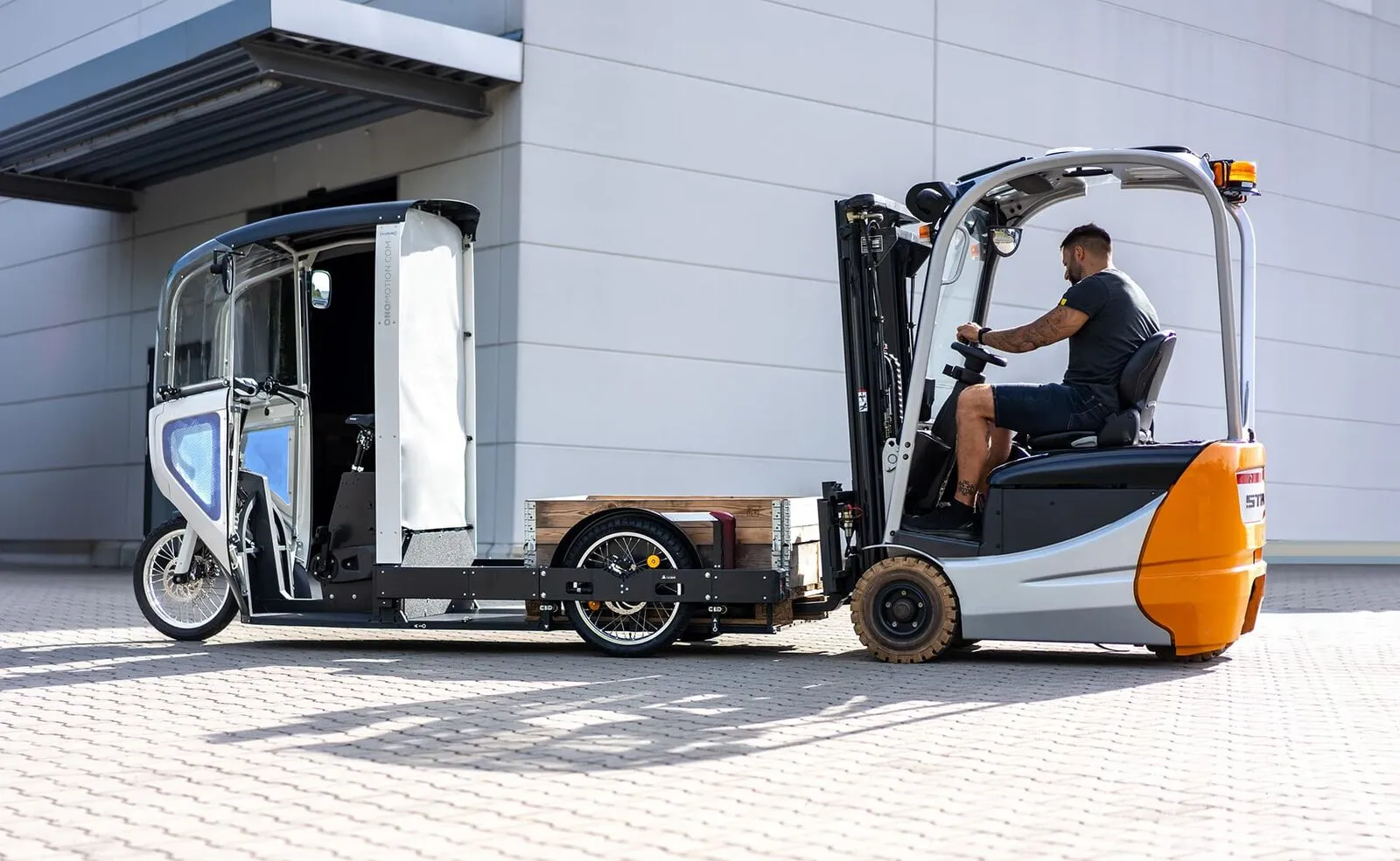 Een heftruck zet de afneembare container op het chassis van de ONO