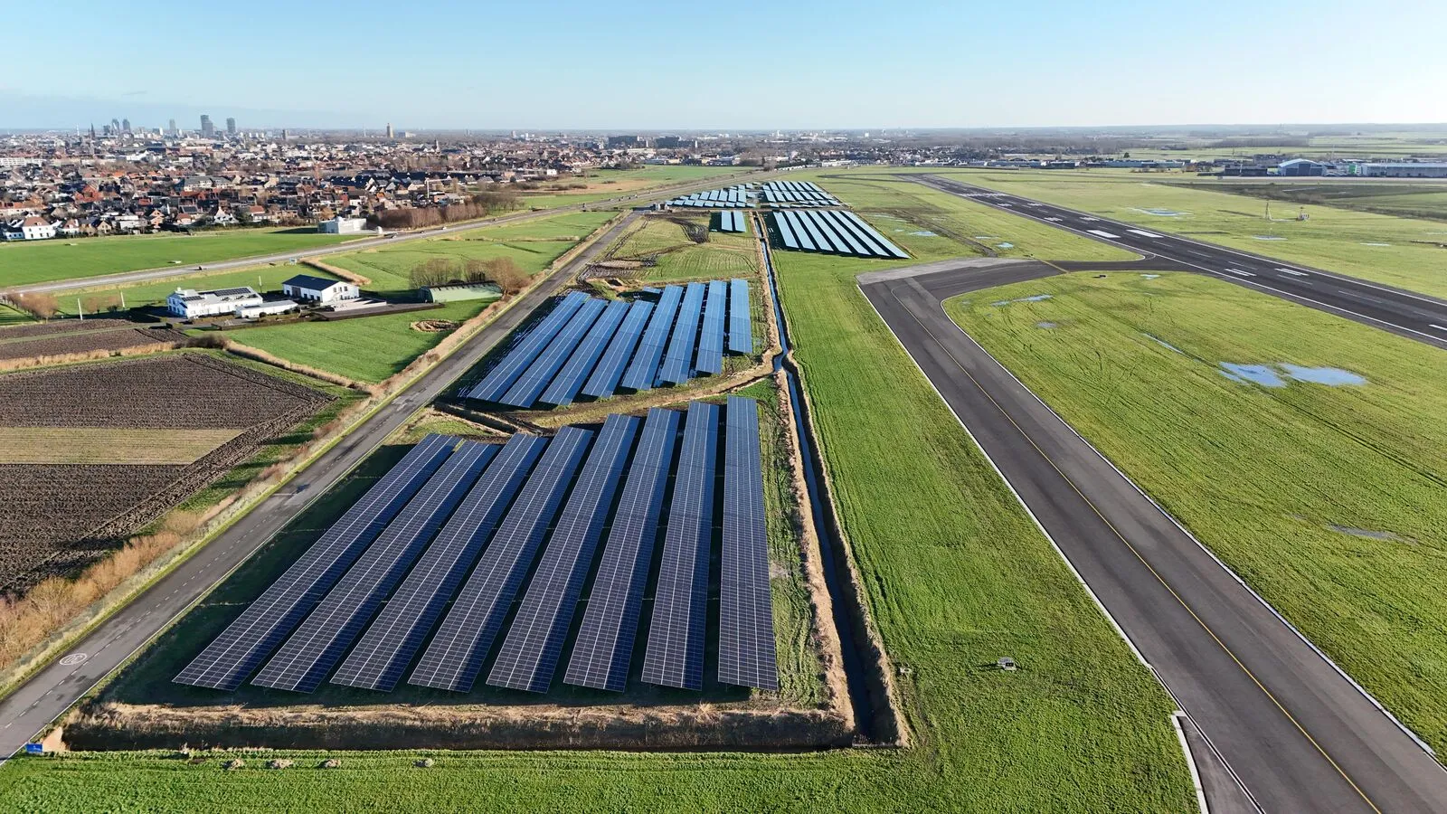 Luchtfoto van het zonnepark langs de landingsbaan van de luchthaven Oostende-Brugge