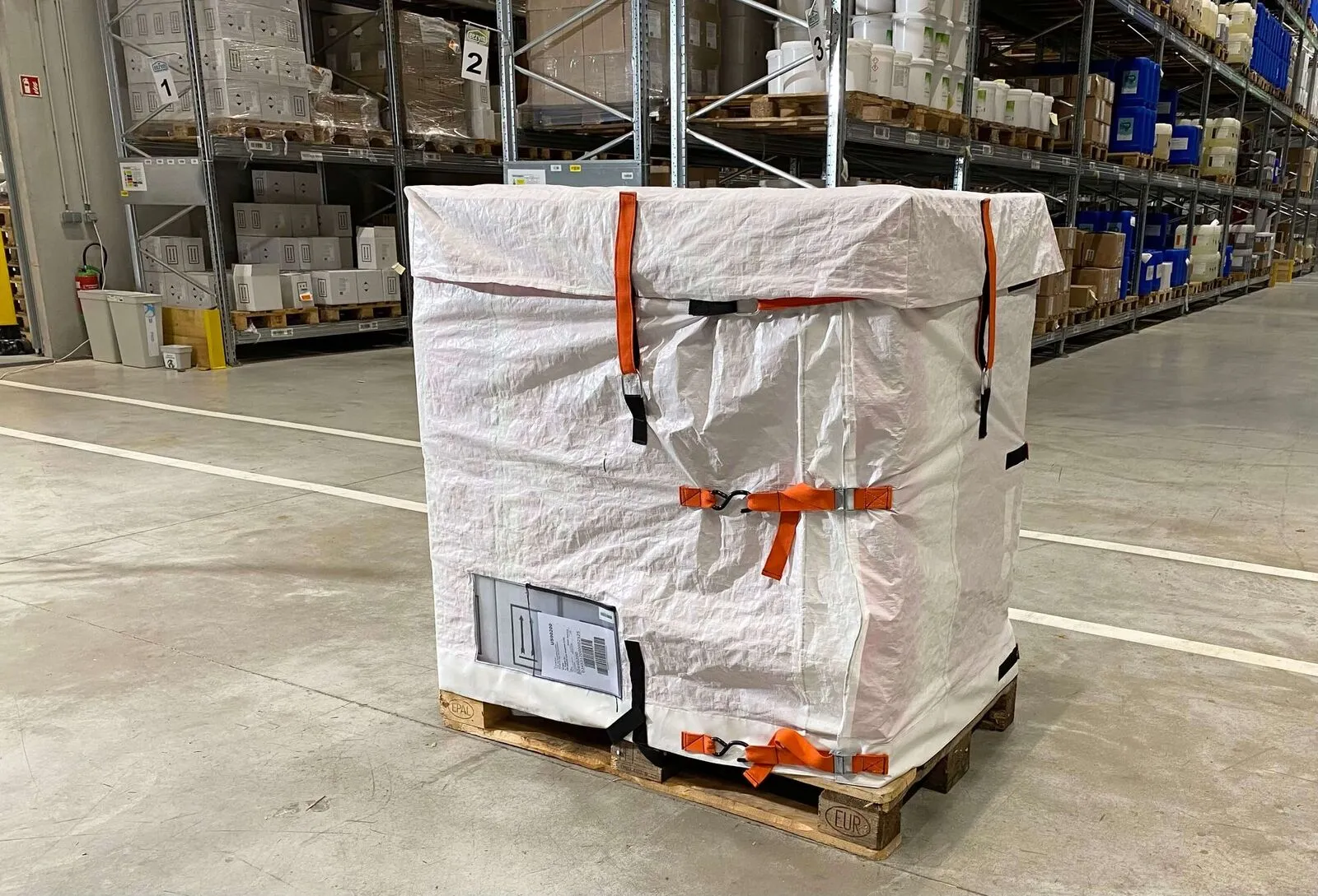 Housse de palette réutilisable LOOPIPAK à sangles orange dans un entrepôt