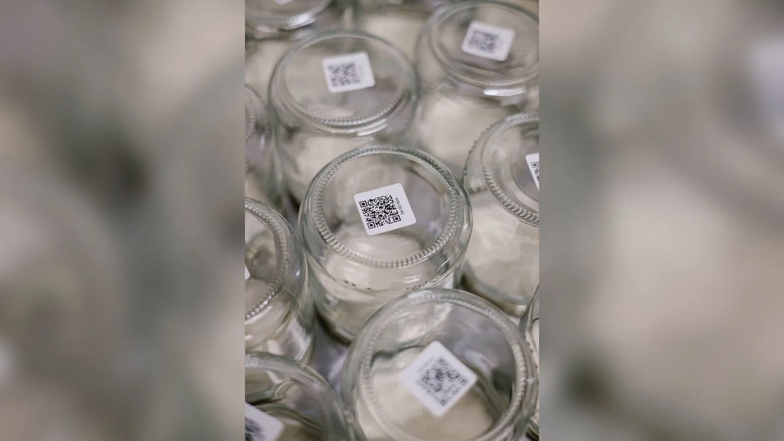 Lege glazen bokalen, elk met een eigen QR-code voor het statiegeld