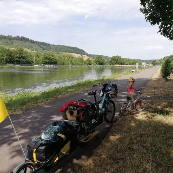Un vélo cargo WELGO sur une piste cyclable au bord de l'eau