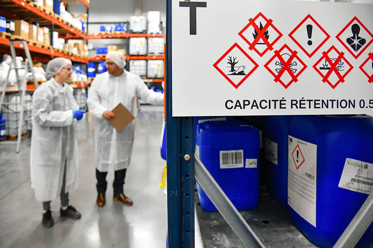 Audit sur site d'une zone de stockage de produits chimiques, avec pictogrammes de danger et capacité de rétention affichée