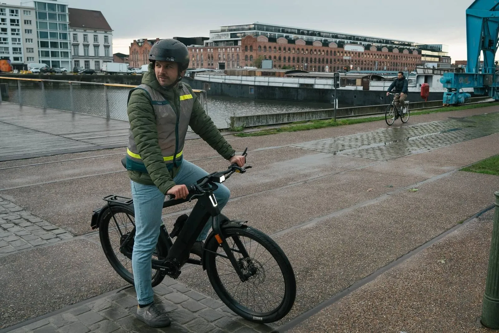 Een pendelaar op een geleasede speedpedelec langs het water in Gent