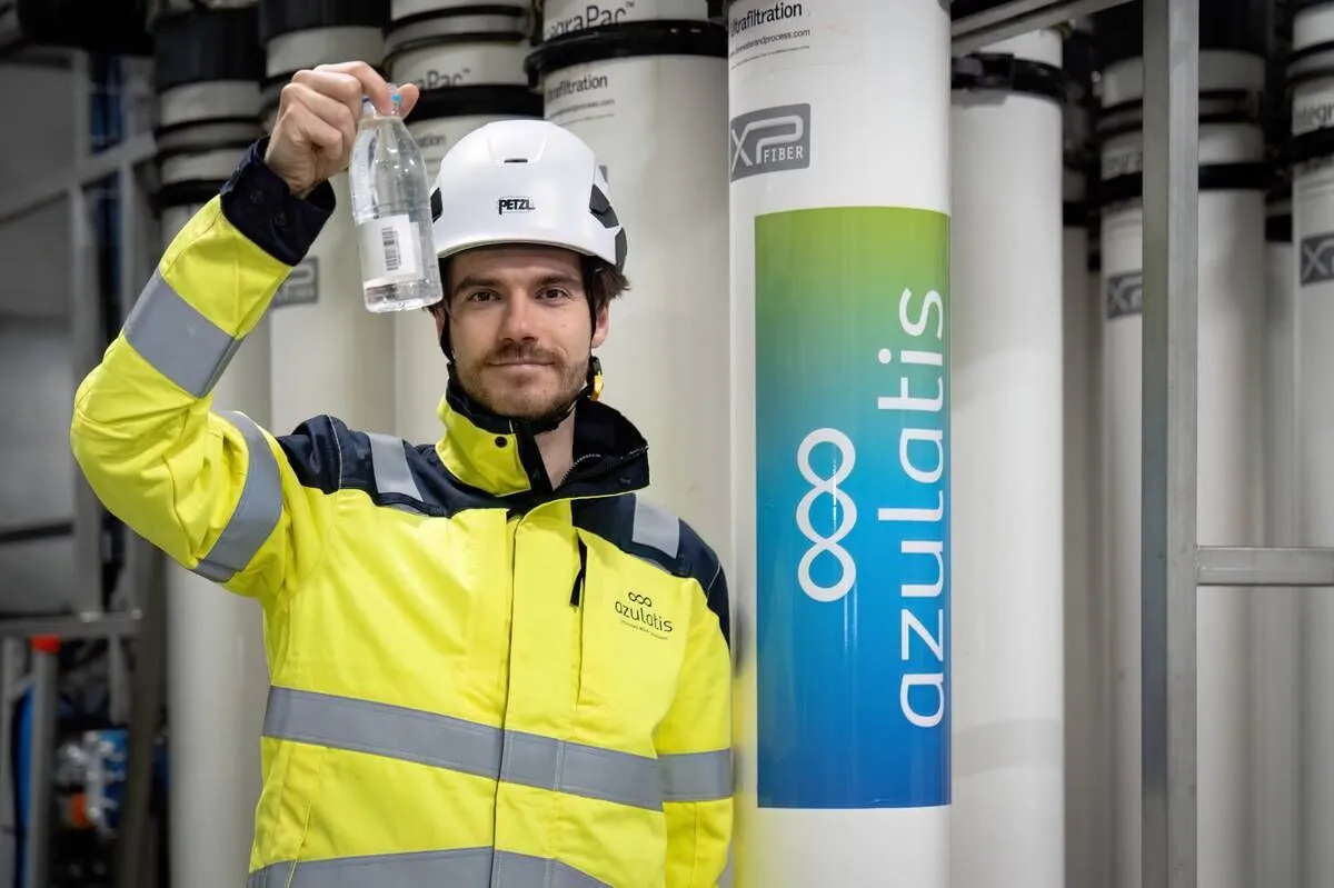 Technicien d'Azulatis montrant un échantillon d'eau traitée à côté des membranes d'ultrafiltration