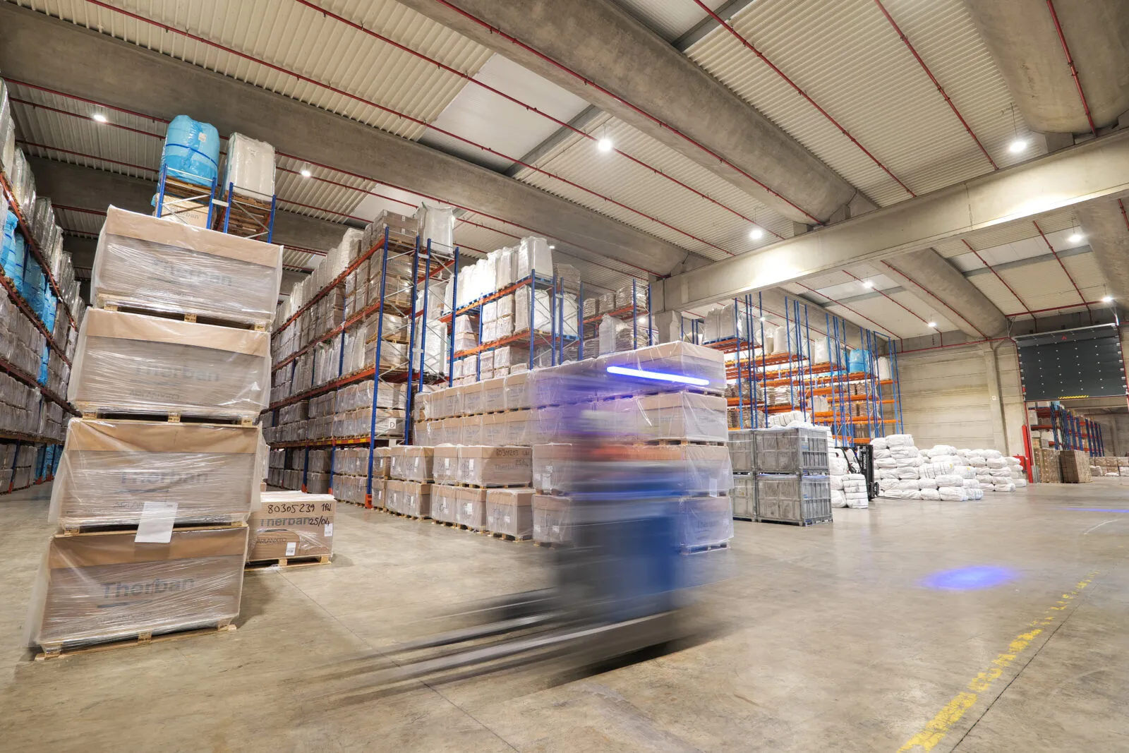Heftruck in een magazijn van Van Moer Logistics met LED-klokken en draadloze sensoren