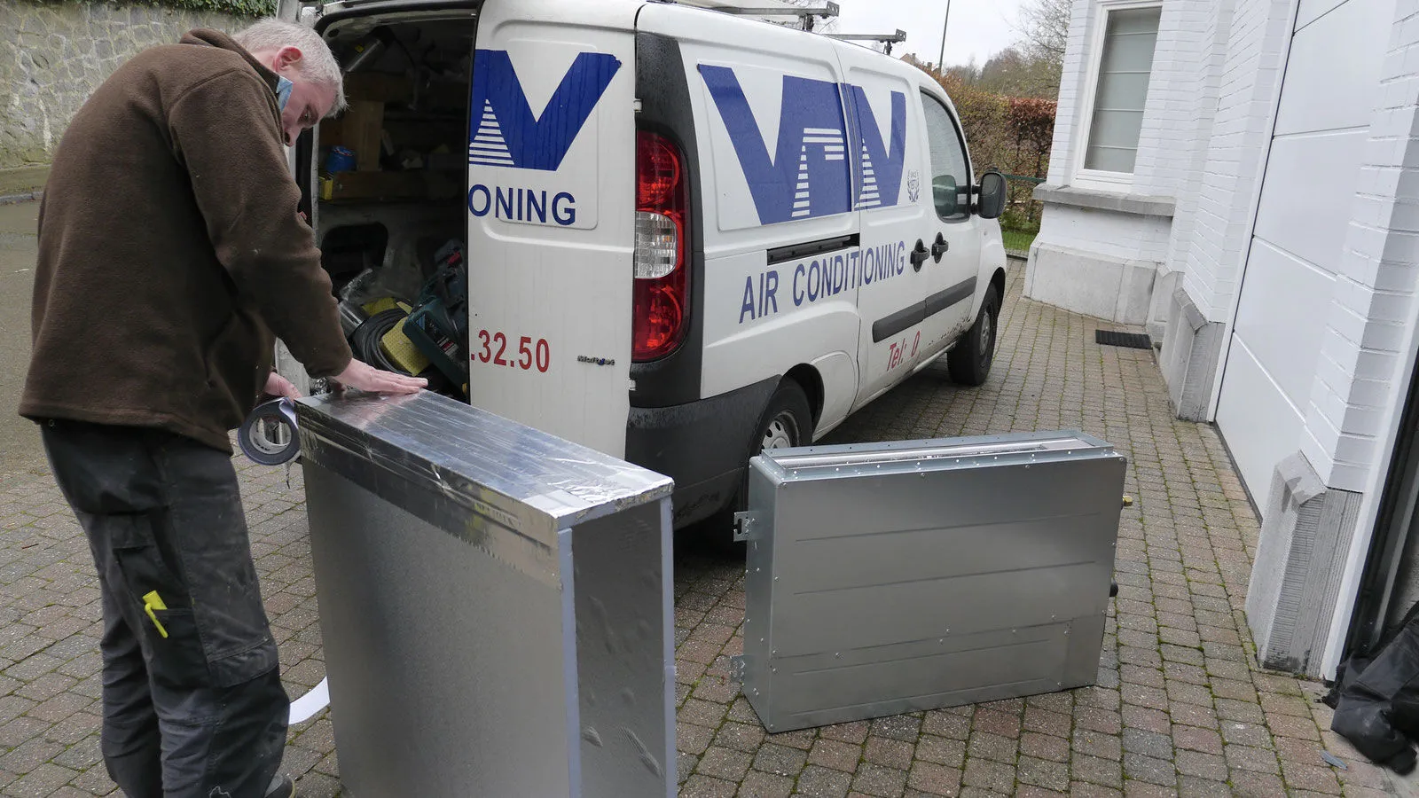 Technicien VDV préparant une installation à côté d'une camionnette de l'entreprise
