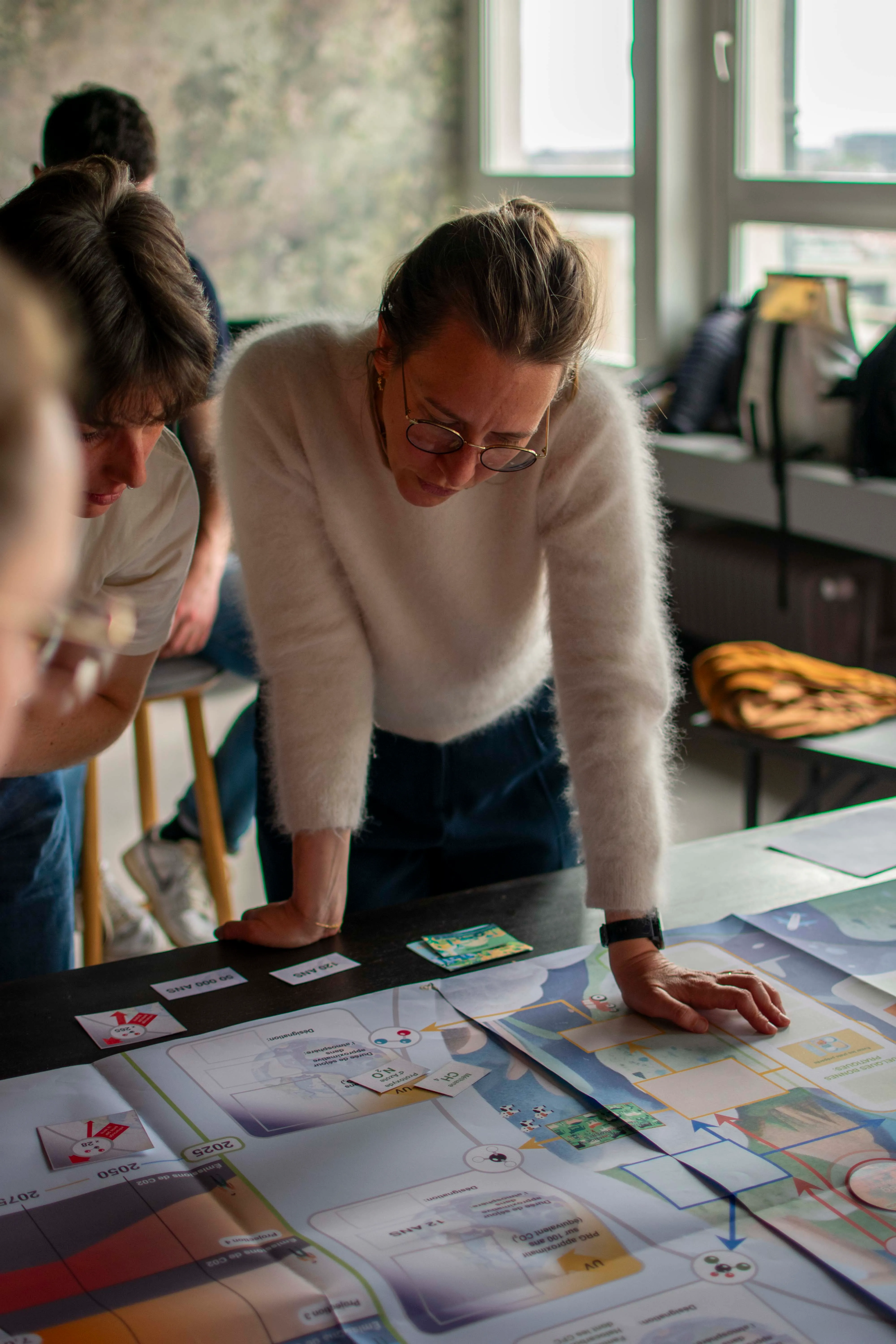 A consultant reviewing a client's carbon trajectory on a printed mapping